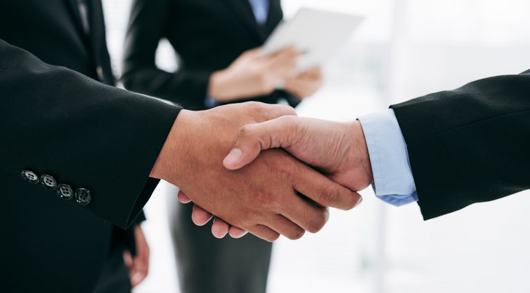 A firm handshake between two business professionals.