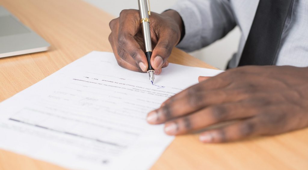A business lawyer signing a legal document.
